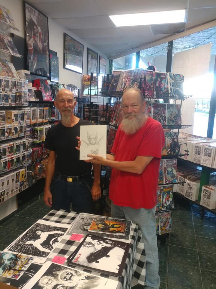 John holding a comic in a shop